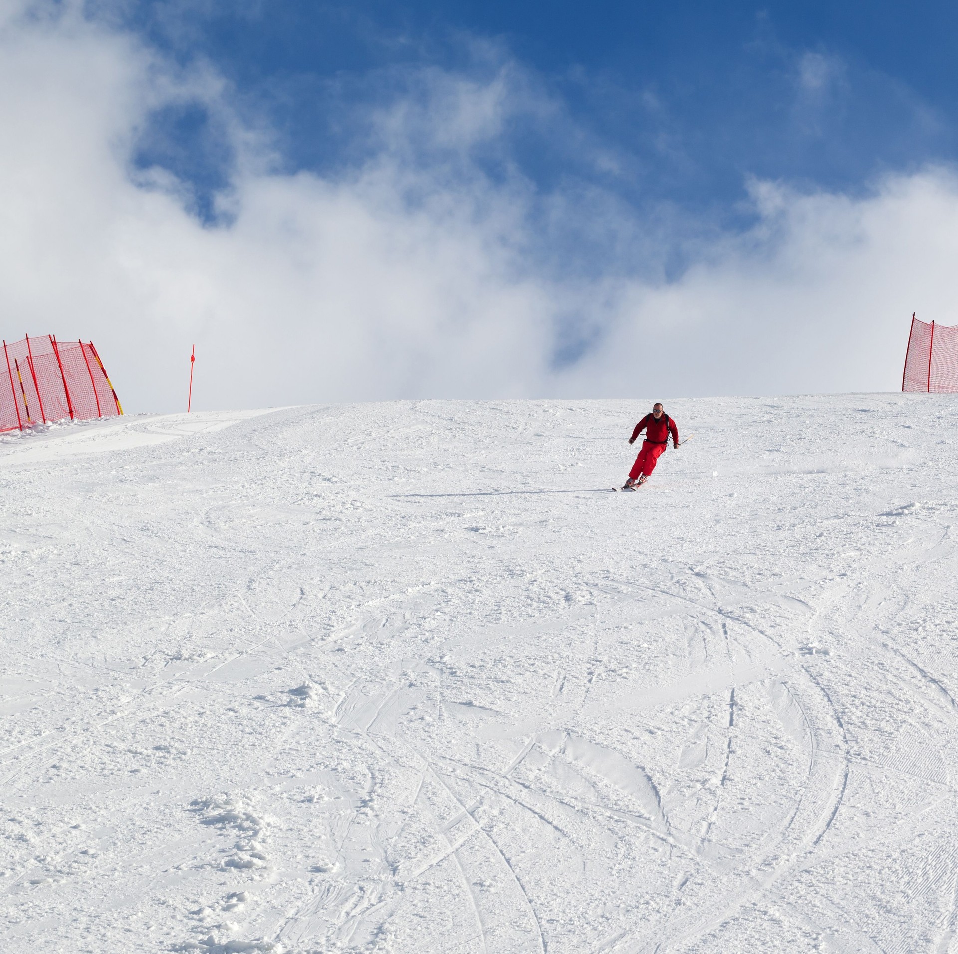 Skier descend on snowy ski slope at winter day