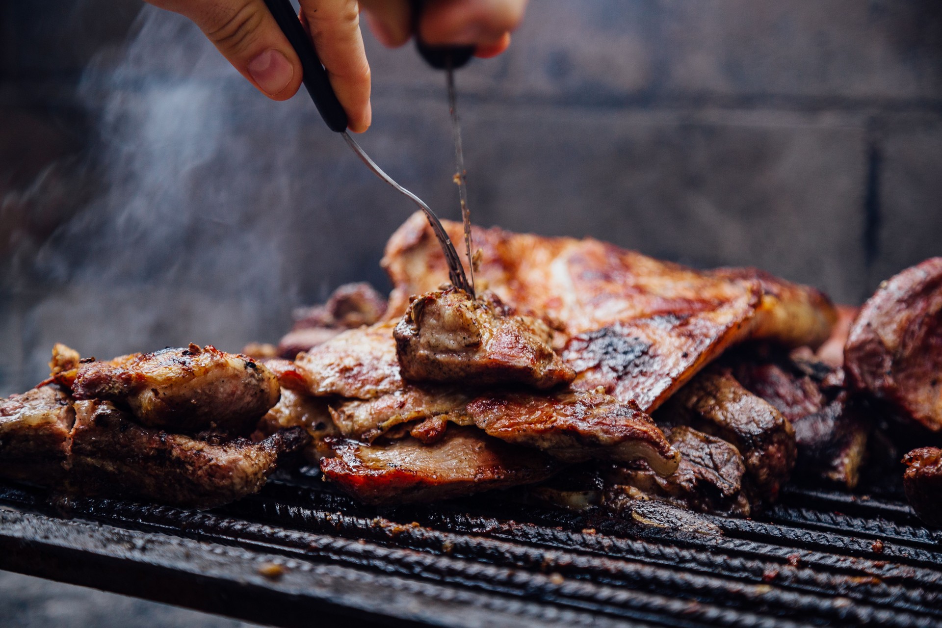Young man doing a bbq. Traditional Asado of Argentina.