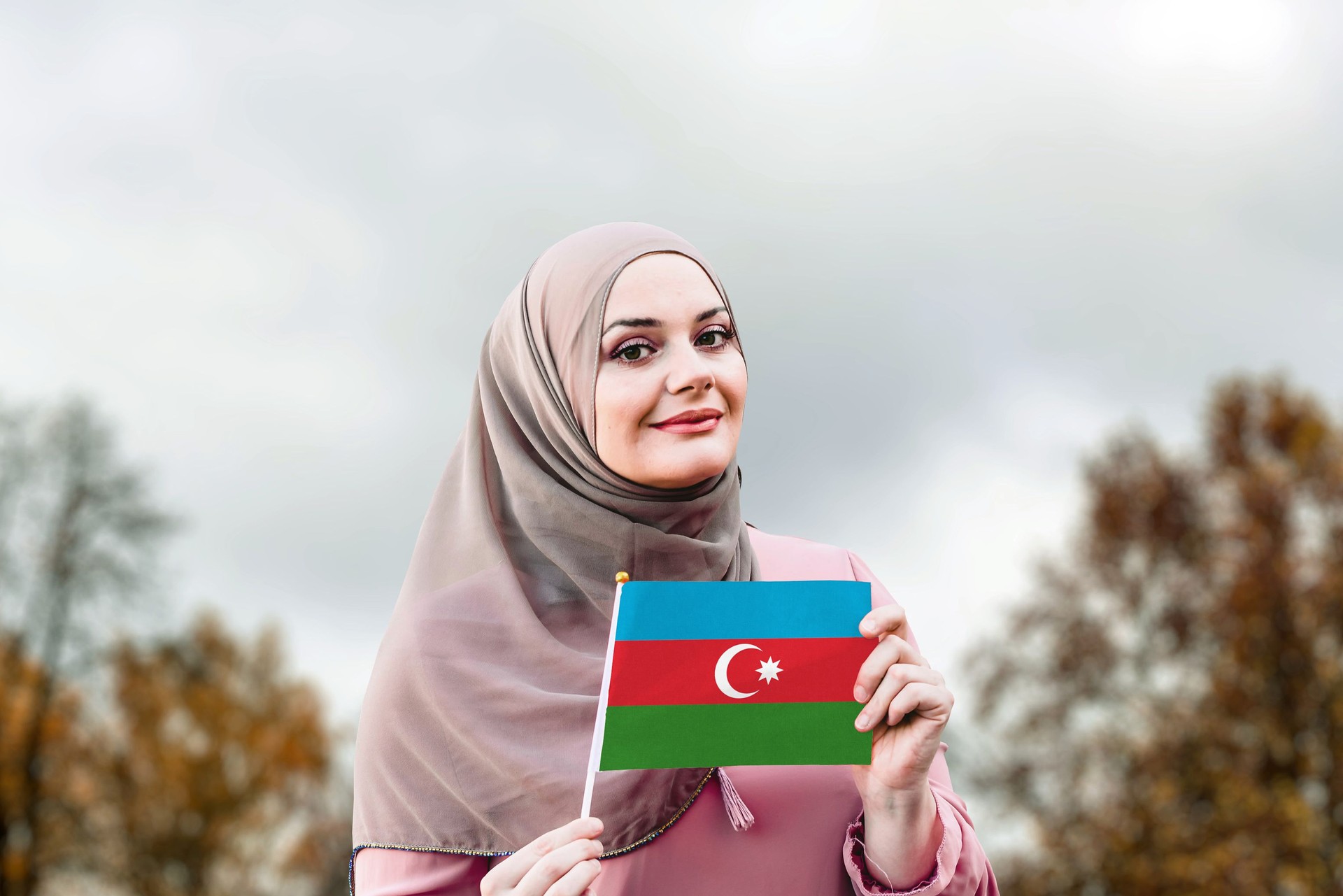 Muslim woman in hijab holds flag of Azerbaijan